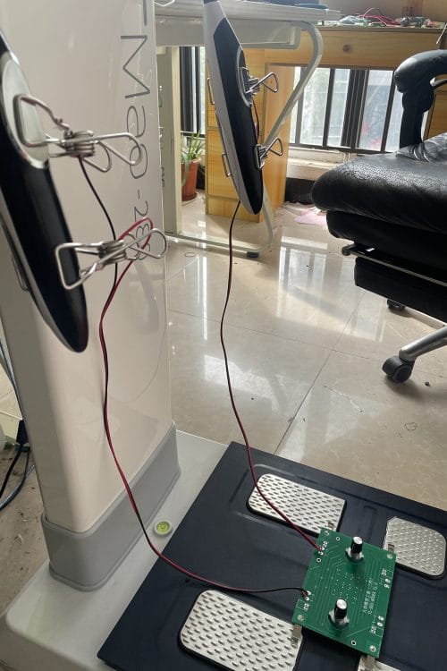 A full system calibration setup, with the iBodyinfo RES-MODER BIA validation tool connected to both hand and foot electrodes of an analyzer.