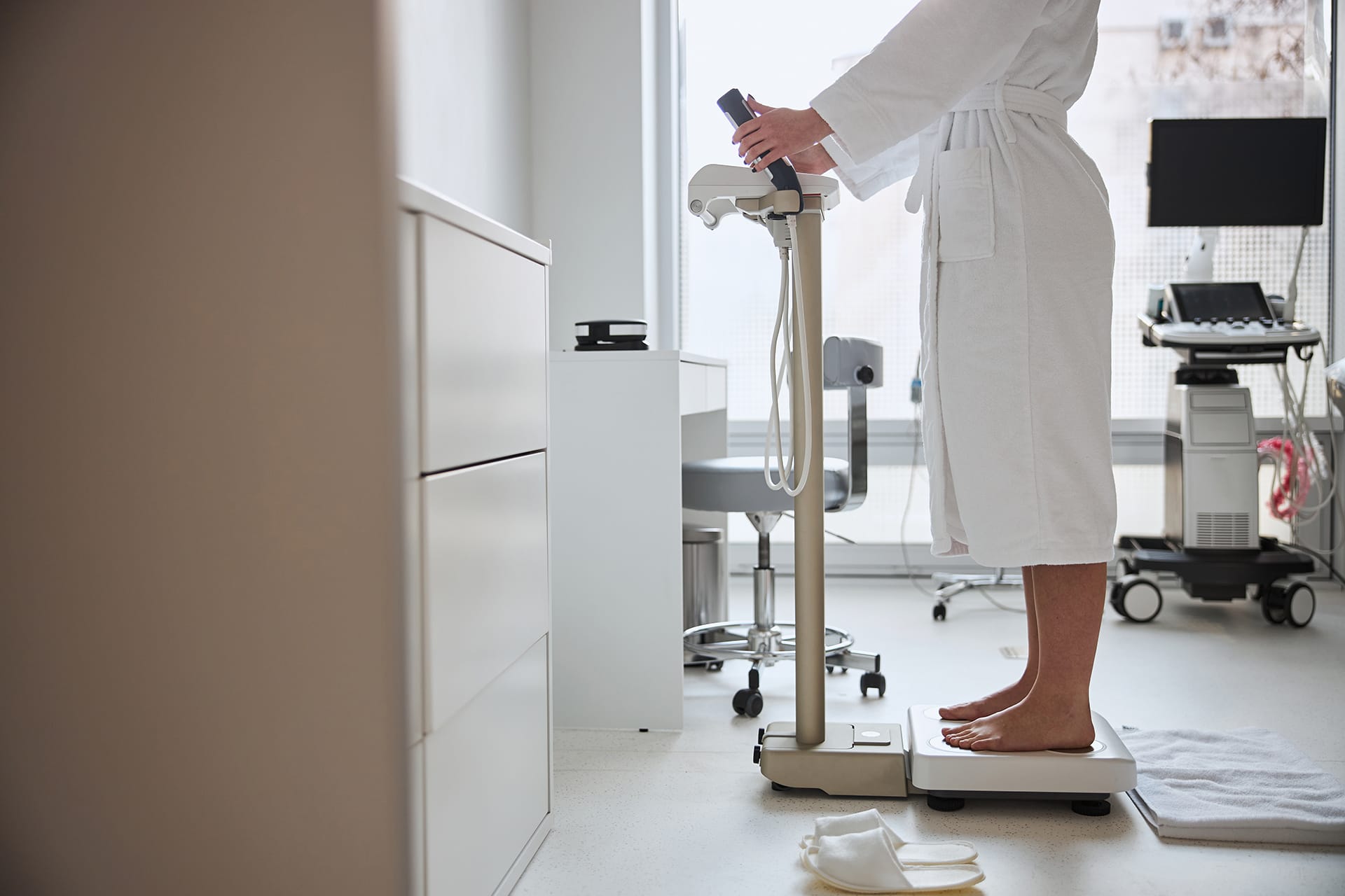 A professional body composition analyzer situated within a modern and bright clinical or wellness center environment.