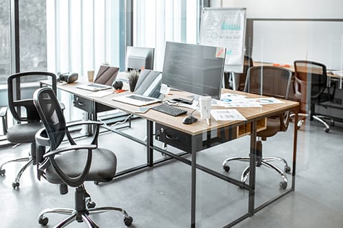A modern technology R&D office with laptops displaying code on the desks, reflecting a collaborative and innovative environment.
